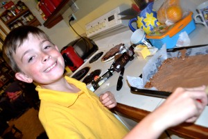 Mister spreading the melted chocolate topping over the base.